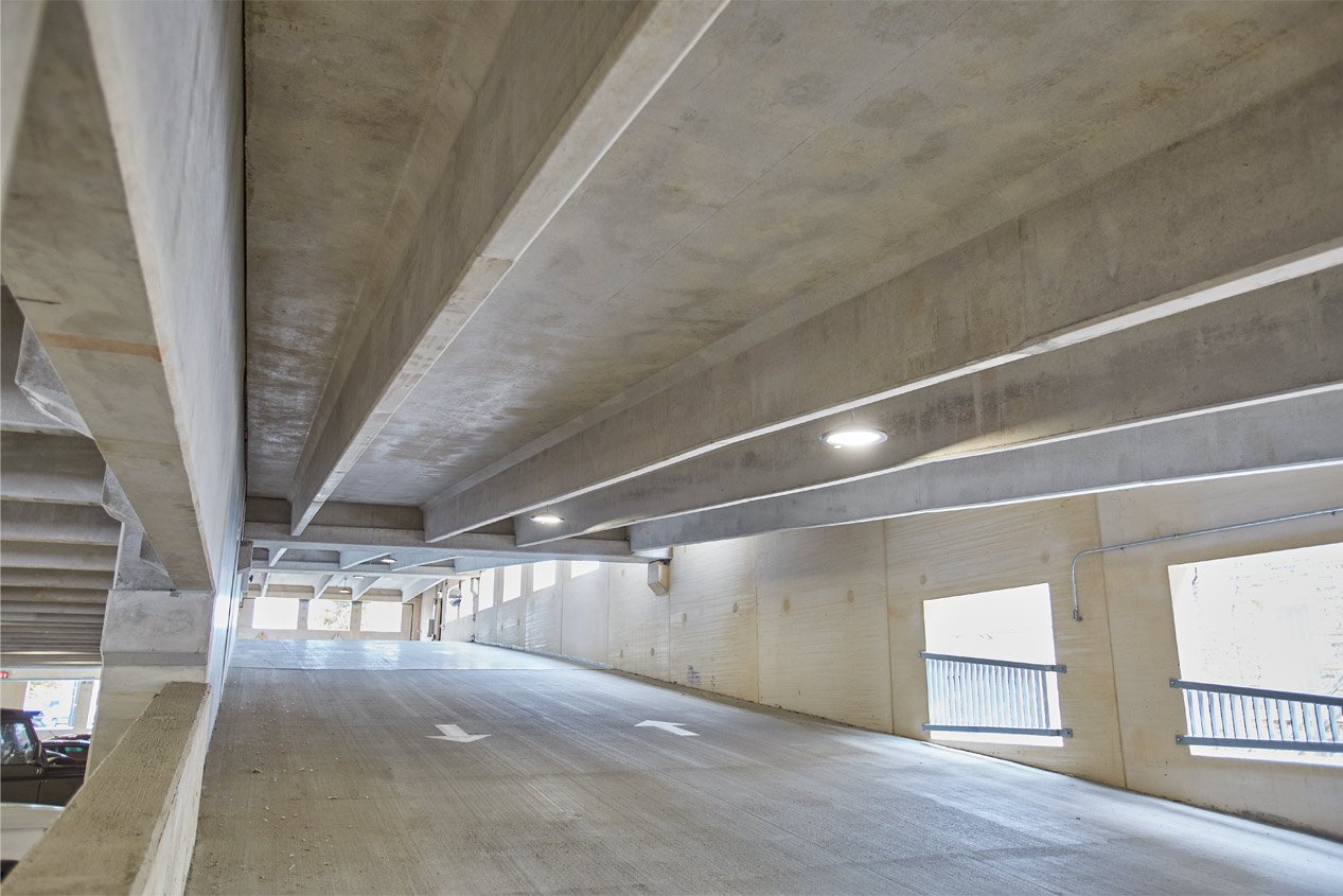 An interior view of a precast parking garage showing pre-topped double tees seen from below.